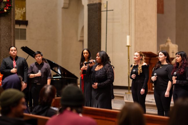 Choir members sing in the SMC Chapel dressed in black
