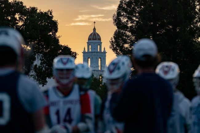 Men's lacrosse players with Saint Mary's Chapel in background, fall 2023