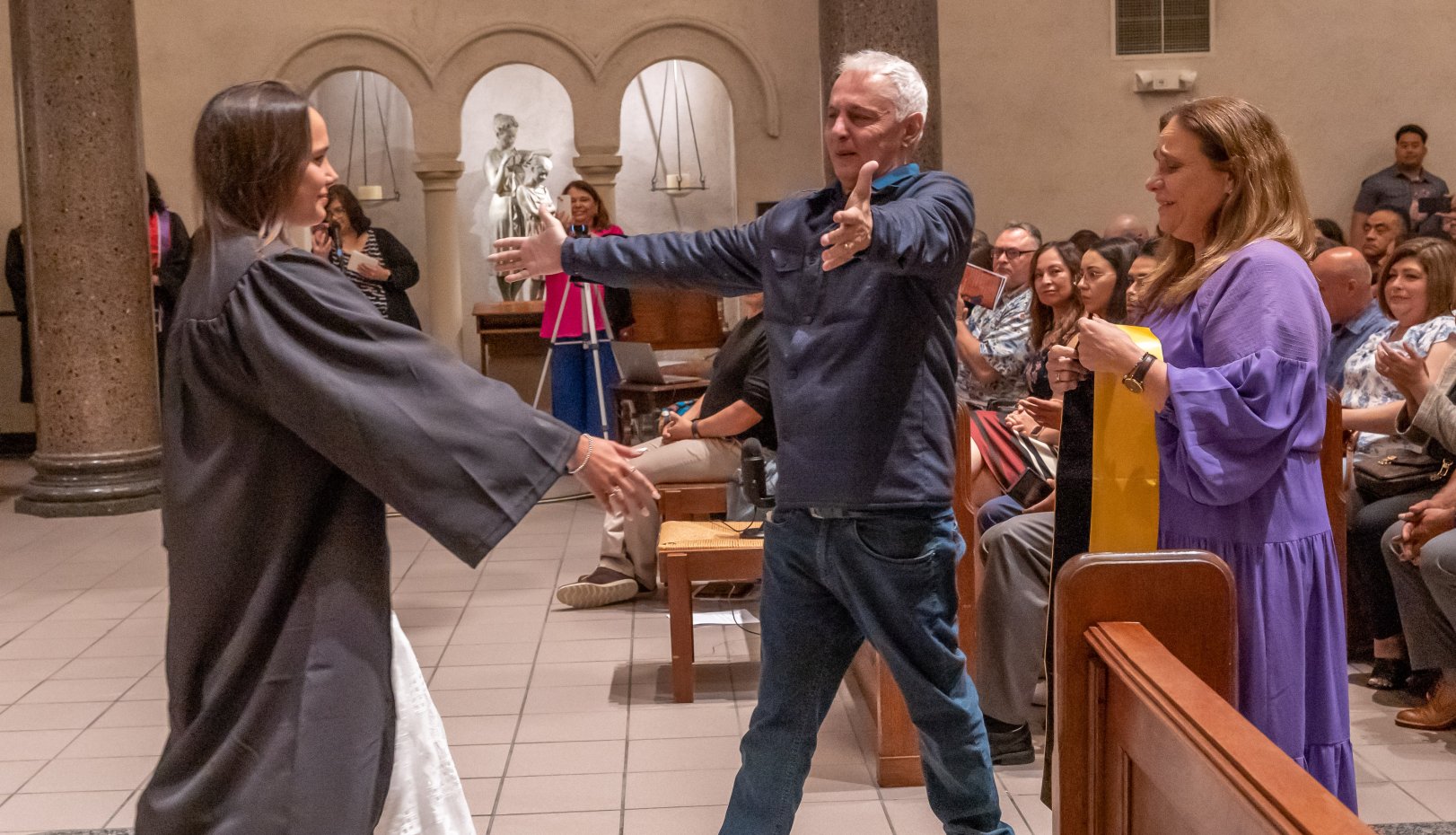 Parents hugging Latinx grad