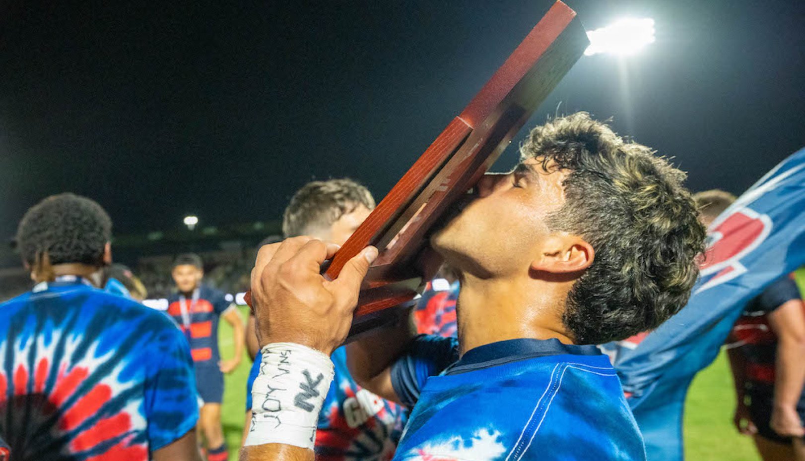 SMC men's rugby player kisses trophy for 2024 National Championship