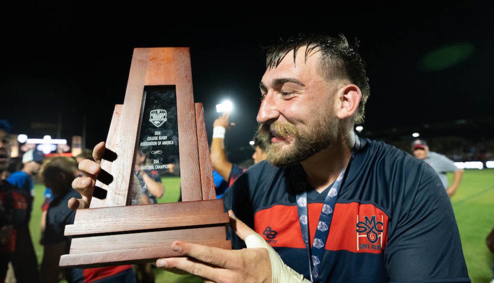 Saint Mary's men's rugby player holds trophy for 2024 National Championship