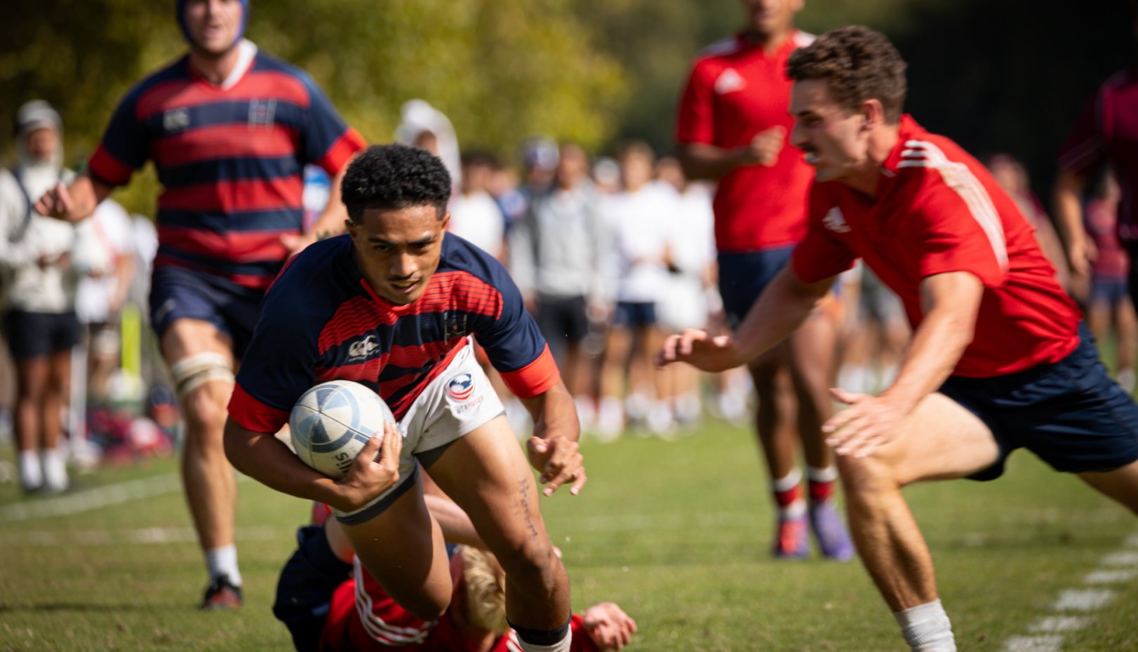 In October 2024 rugby scrimmage match, player runs with the ball while another tries to tackle him