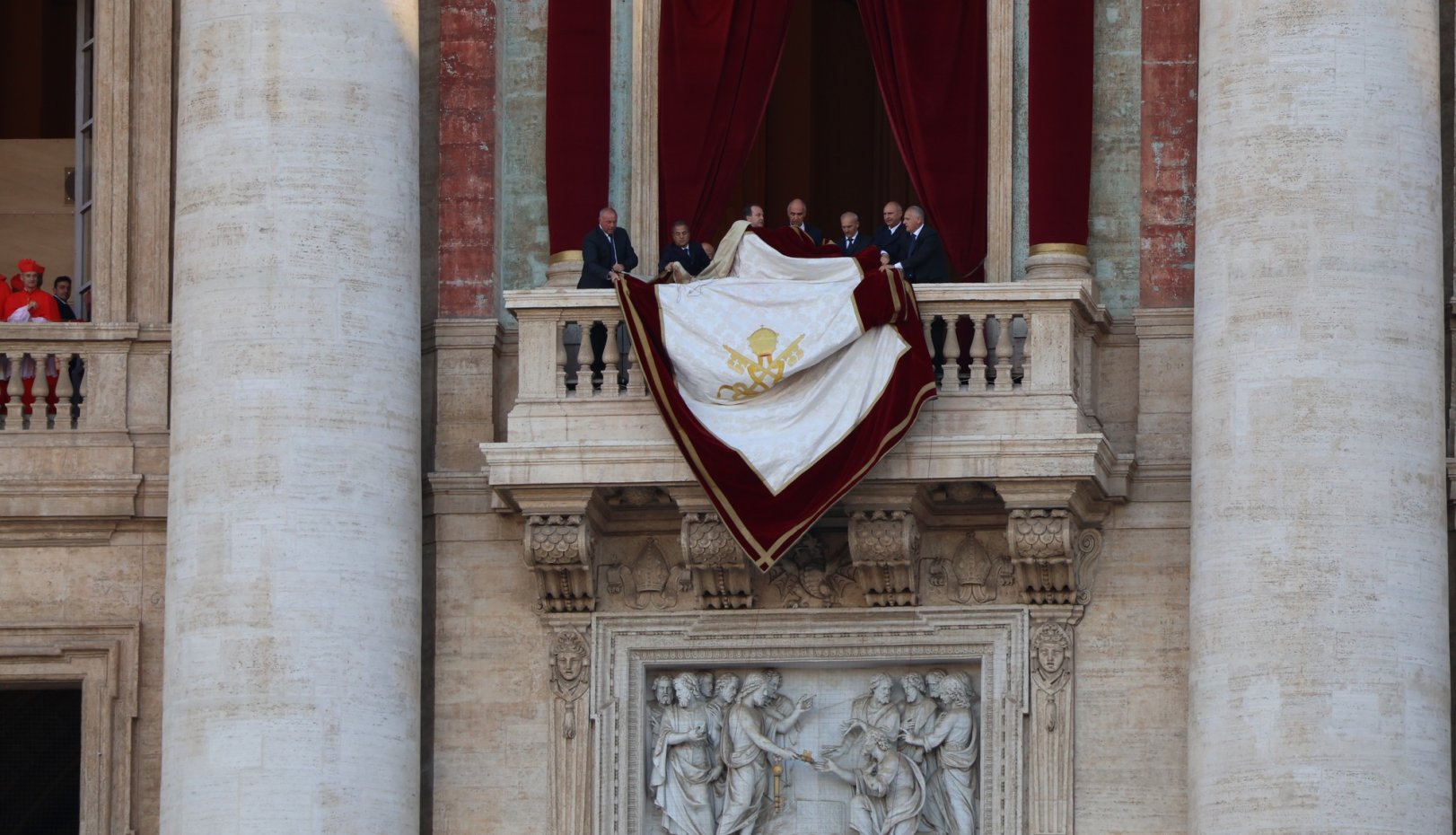 a banner is hung from the balcony at St. Peter's in Rome in may 2025