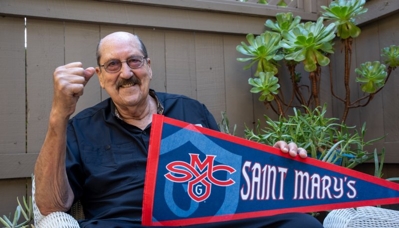 Tom Meschery holds an SMC pennant on his patio