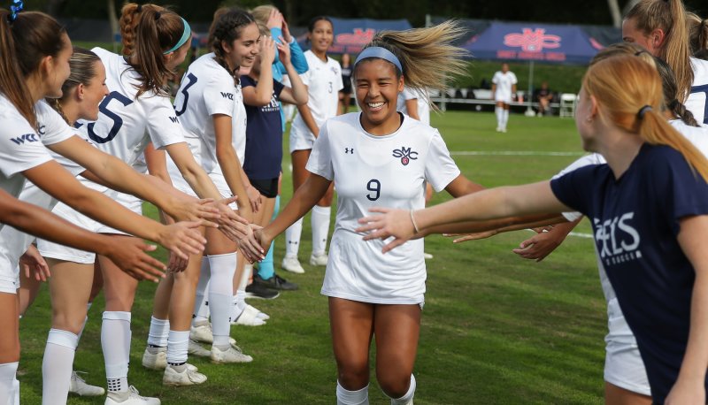 Women's Soccer player Makena Carr congratulated by teammates after victory over Portland in fall 2023