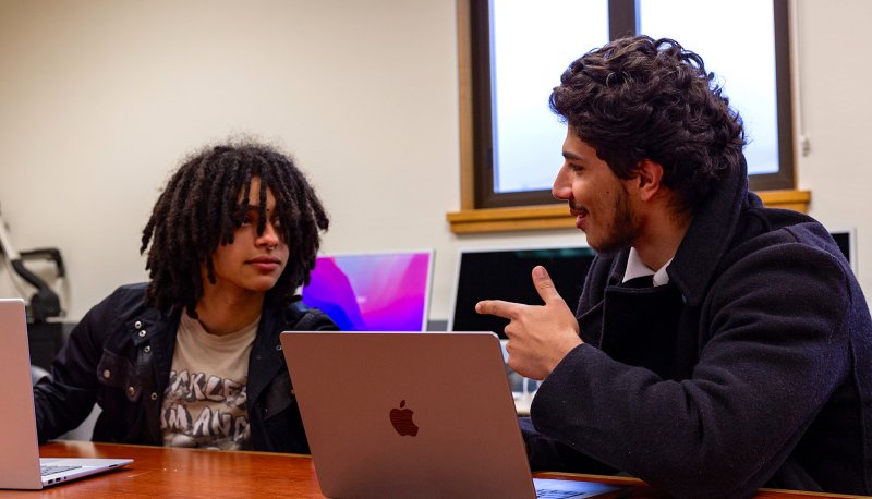 Debate students Jasper Pacheco ’27 and Luis Mora ’27 at a table, spring 2024