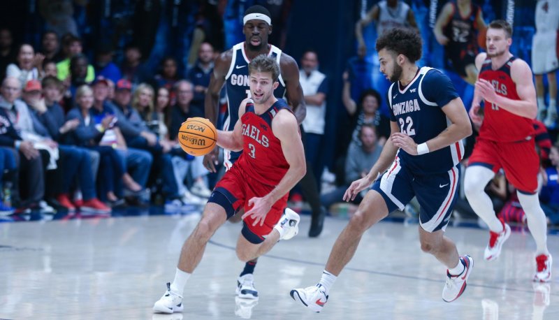 Augustas Marciulionis drives against Gonzaga, with 2 Gonzaga players and teammate Mitchell Saxen in the background