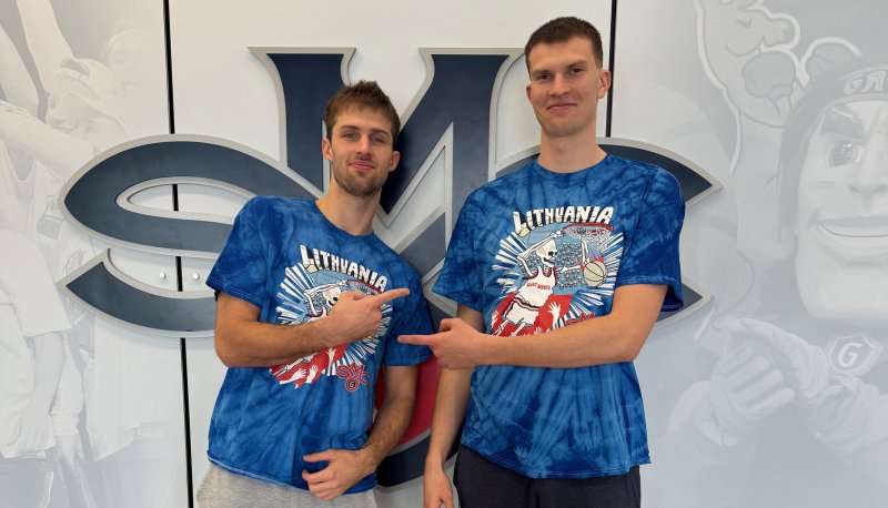 Men's basketball players Augustas Marciulionis and Paulius Marauskas in front of the SMC logo