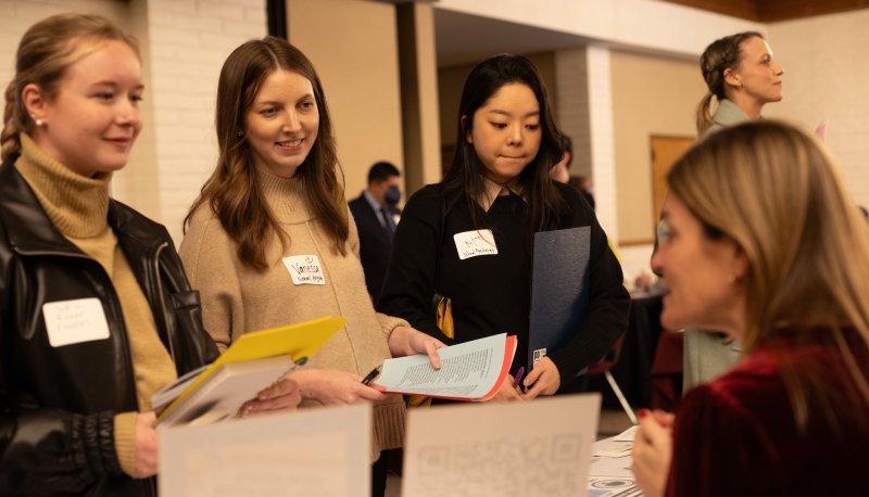 Three students talk with a recruiter at the KSOE Career Fair in February 2025