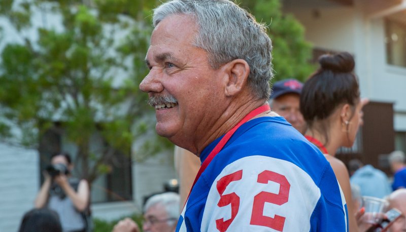 An alumnus wearing an old football jersey smiles during Reunion