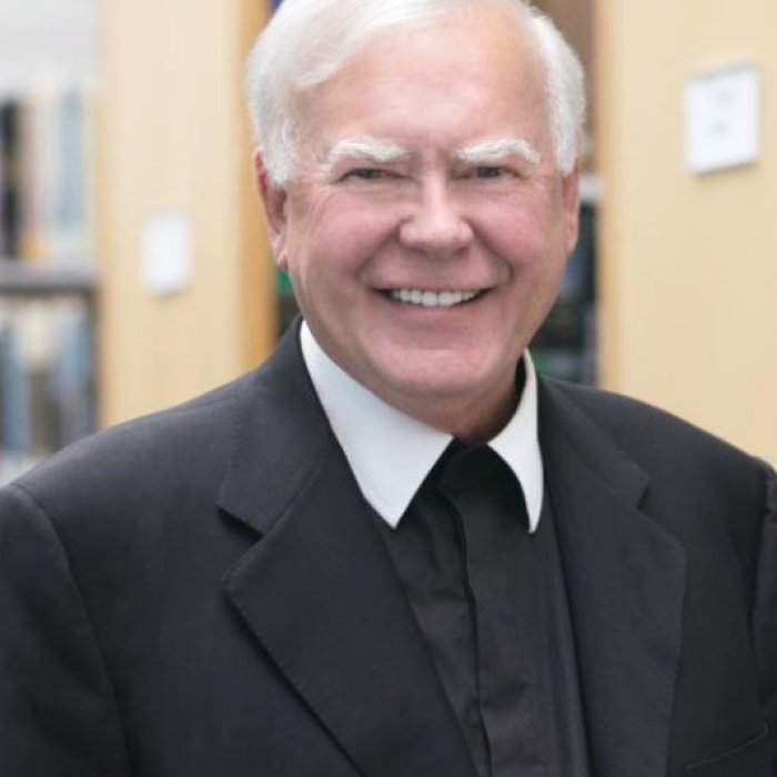headshot photo of Br. Ronald Gallagher with bookcases in background