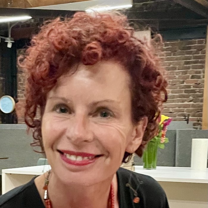 Dana Lawton, a red-headed woman, smiling towards the camera