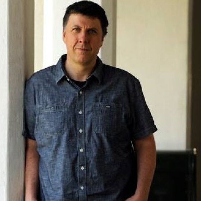 Photo of Professor Matthew Zapruder leaving against a white pillar