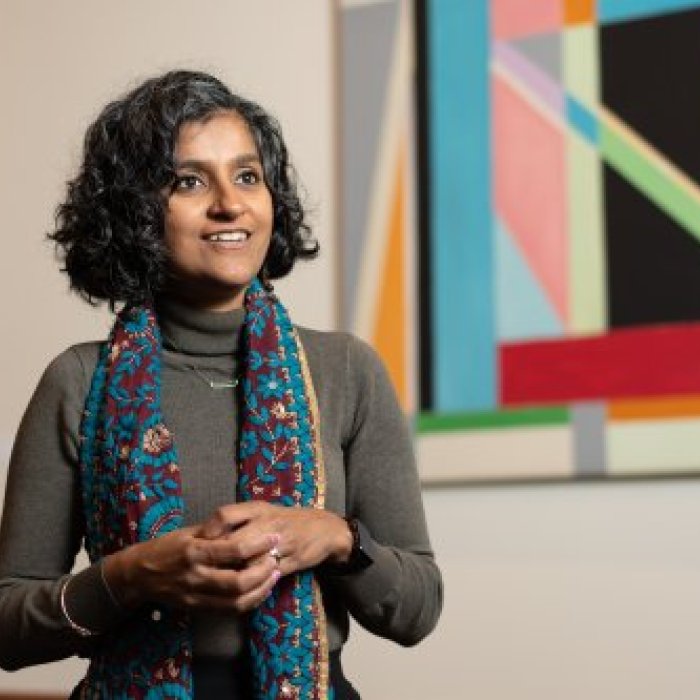 Photo of Professor Sunayani Bhattacharya with paintings in background