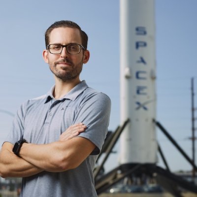 Alex Stillings in front of SpaceX rocket