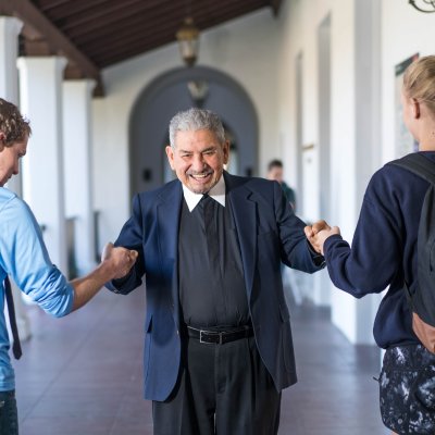 Brother Camillus giving fist bump to students