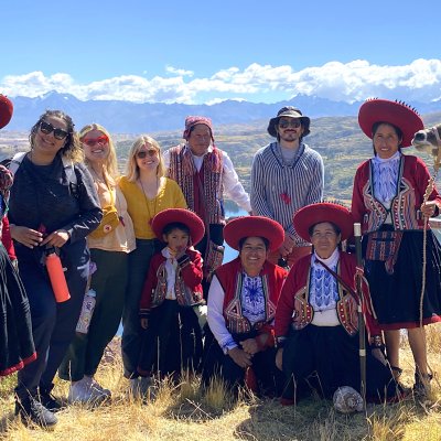 Saint Mary's alumni and Peruvians on a ridge with a llama