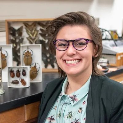 Abbey Hayes '16 smiles next to insects on display in a science lab