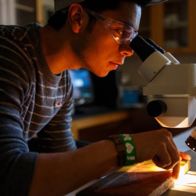 Master’s Degree in Biotechnology student looking through a microscope