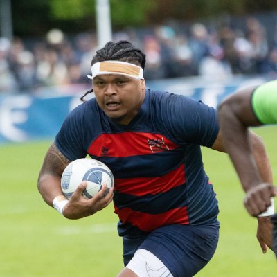 SMC men's rugby player King Matu ’24 runs with the ball with a referee to his left and a Cal defender in front of him, April 2024