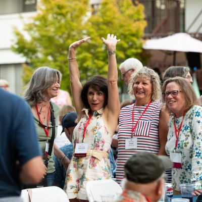 Jeanette Leong '84 holds her hands in the air to greet a friend at Reunion