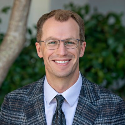 Business faculty member Grant Rozeboom with screened-in image of campus behind him
