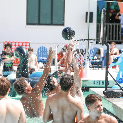 First years gather in the shallow end to play pick-up basketball in the pool during the Weekend of Welcome Pool Party on August 24, 2024. / Photo by Ashleen Rai ‘26