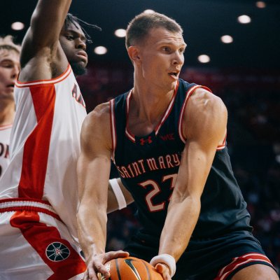 Men's Basketball player Paulius Murauskas holds the ball with defenders from Arizona in the background
