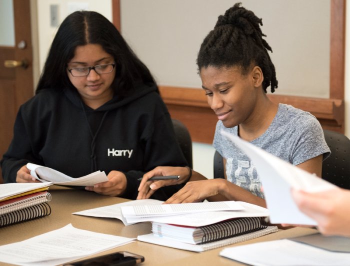 Students in class looking at their papers smiling