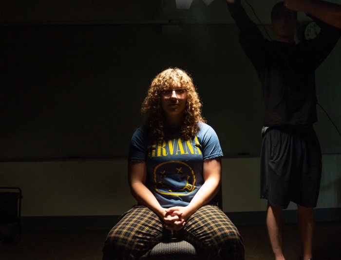 A student sitting under a light in a lighting class