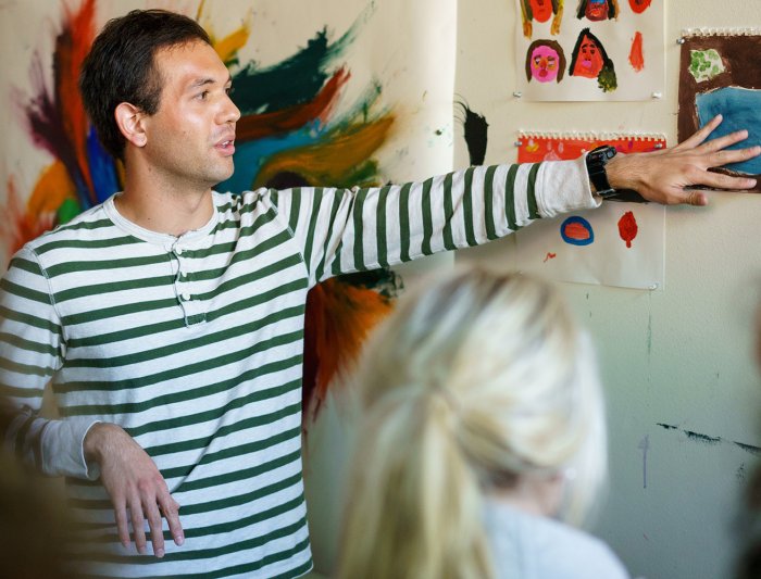 a photo of a student presenting their art in front of an art class