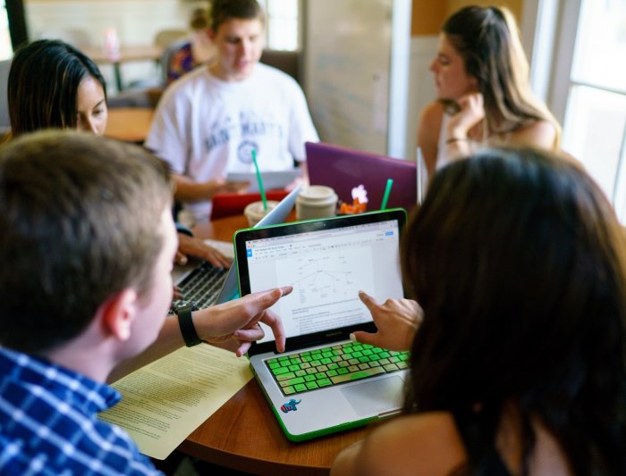 A Writing Circle Facilitator and a writer looking at a laptop screen.