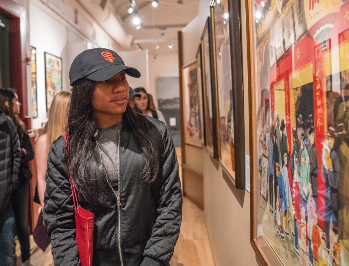 A student in a public history class looking at a historic photo on the wall in Japan town