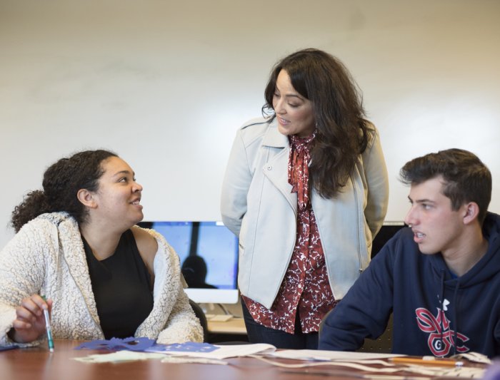 Student talking to a professor in class