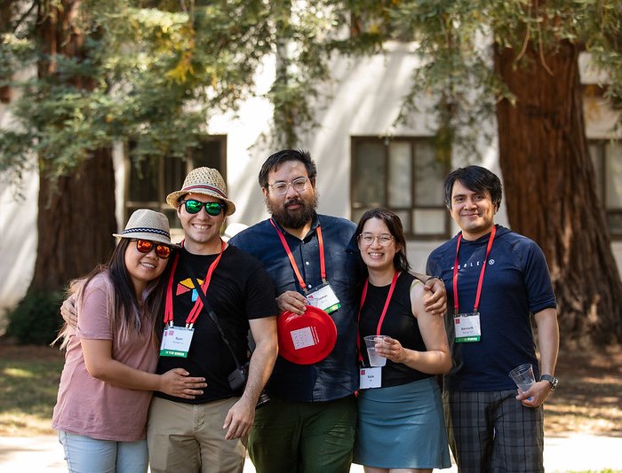 Five people smile at the camera during Reunion