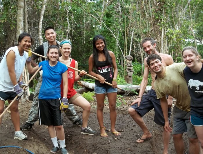 Eight Saint Mary's students posing for the photo with trees from the Brazilian rain forest in the background