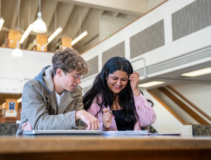 Students in the library smiling and laughing