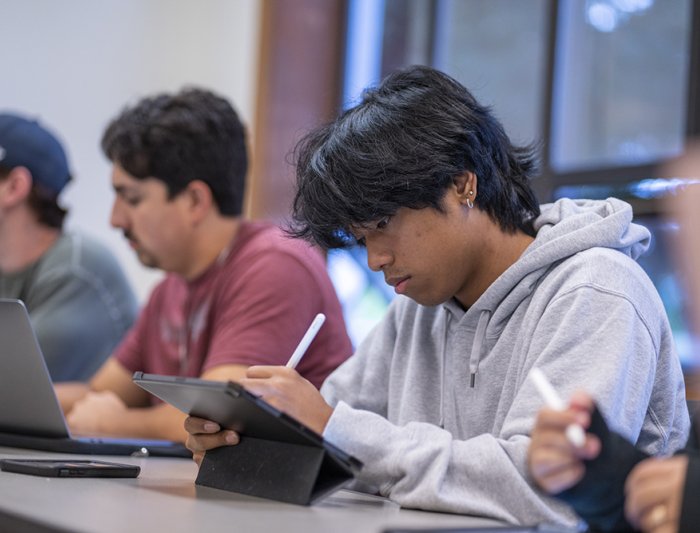 Student taking notes in a classroom