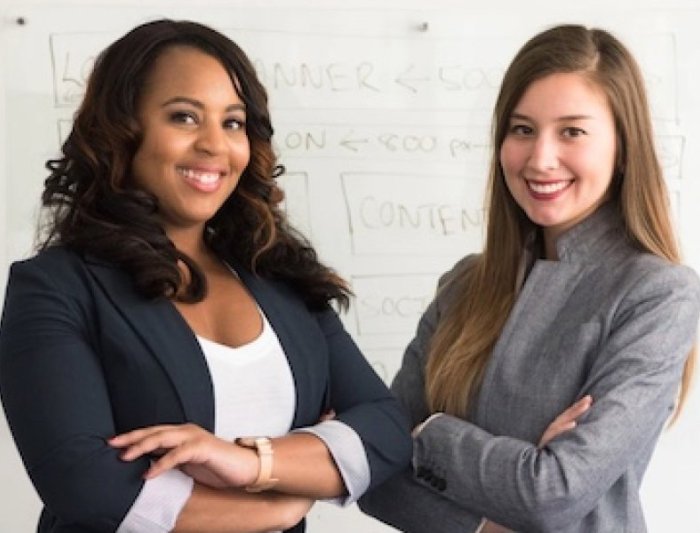 Two students in suits smiling