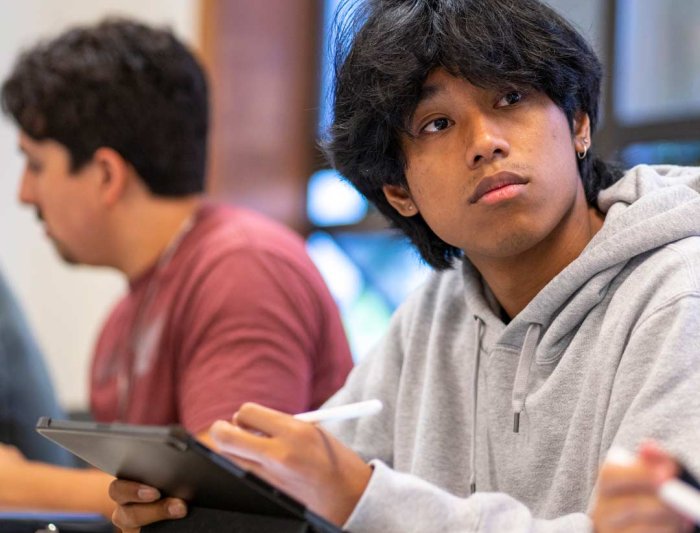 A student in class taking notes on an ipad