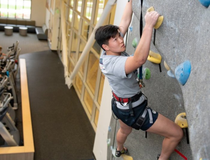 person climbing on indoor rock wall
