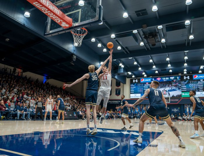 A basketball player dunking during a game