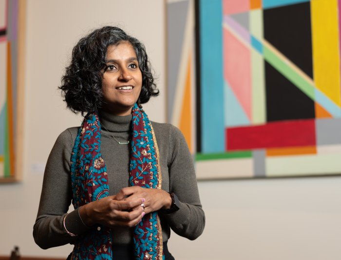 Bhattacharya in front of a colorful background