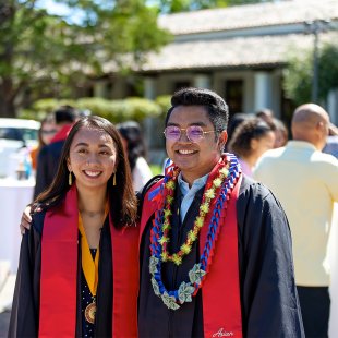 Two graduates posing for a photo after graduation