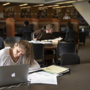 student writing in library