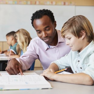 Male teacher teaching a student in the classroom