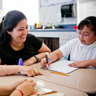 A teacher helping students at their desks