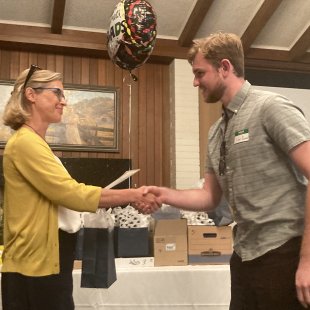 A student and a professor shaking hands in a ceremony