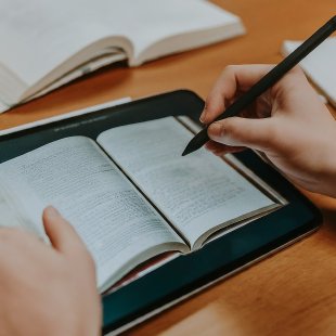 Student reading a book on a tablet