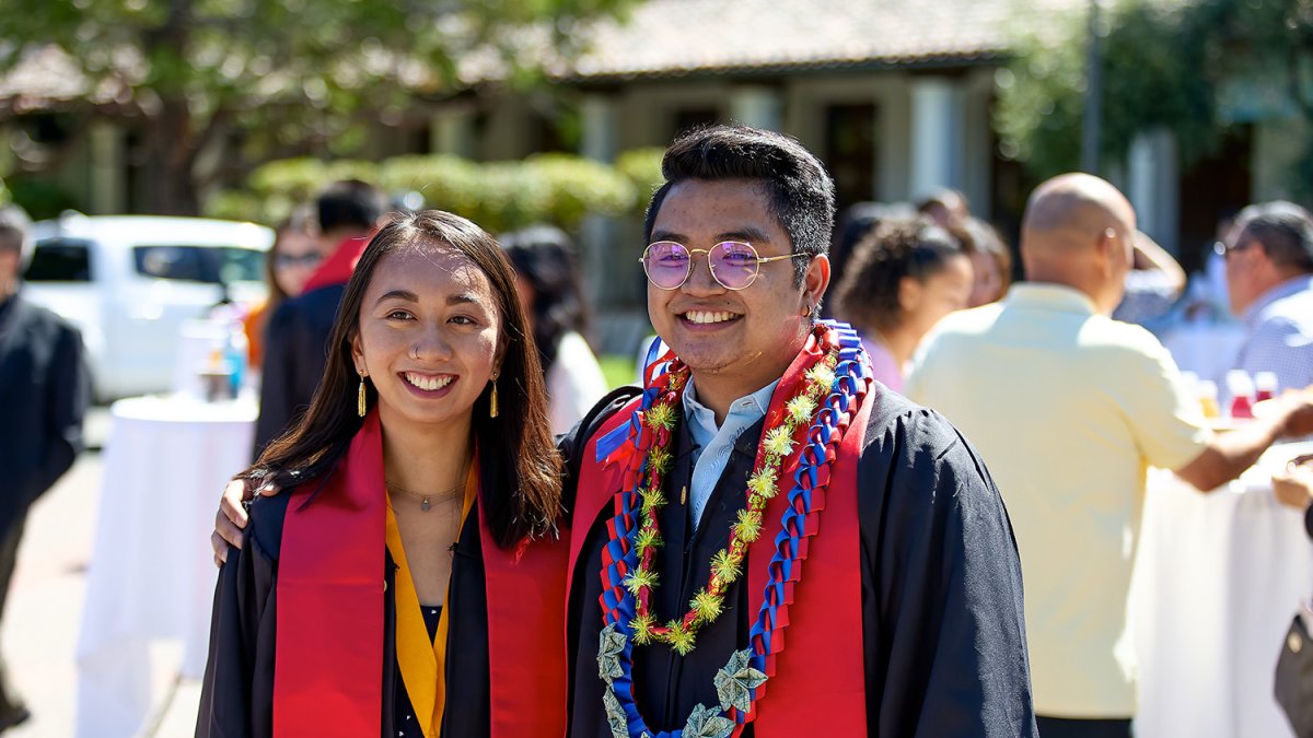 Two graduates posing for a photo after graduation
